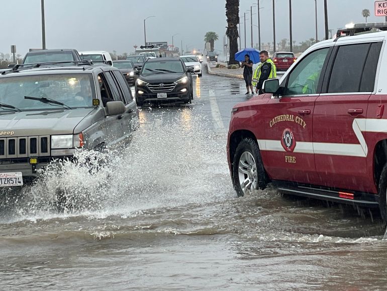 Vehicles moving through a flooded junction in Palm Springs