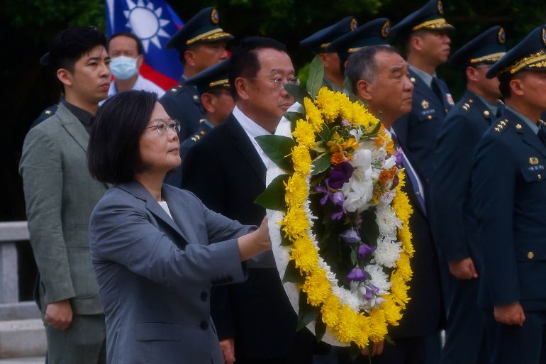 Taiwan President Tsai Ing-wen pays tribute to the fallen soldiers during a ceremony commemorating the 65th anniversary of the Second Taiwan Strait Crisis, in Kinmen, Taiwan August 23, 2023. She holds a wreath lined in yellow flowers.