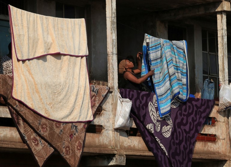 A woman hanging laundry on a washing line in Harare