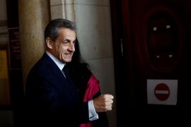 Former French President Nicolas Sarkozy arrives for his appeal trial on charges of corruption and influence peddling, at Paris courthouse