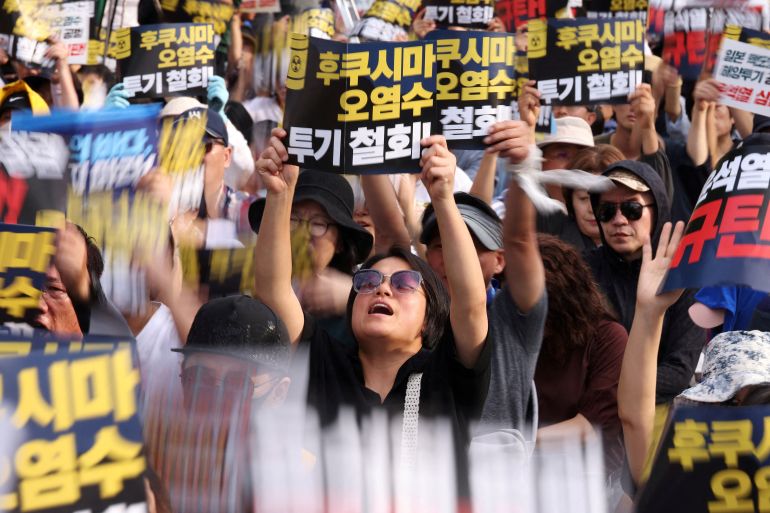 South Korean people chant slogans during a protest against Japan's discharge of treated radioactive water from the wrecked Fukushima nuclear power plant into the Pacific Ocean, in Seoul, South Korea, August 26, 2023. The sign reads "Withdraw discharge of Fukushima wastewater!".