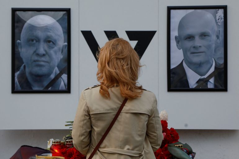 A woman stays in front of a makeshift memorial for Yevgeny Prigozhin, head of the Wagner mercenary group, and Dmitry Utkin, group commander, in Nizhny Novgorod, Russia