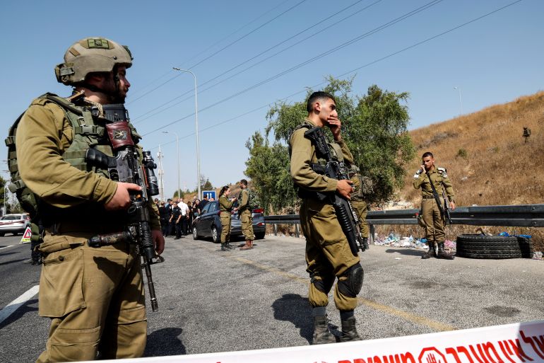 Israeli soldiers attend the scene at which, according to Israeli police, a truck driver hit several soldiers