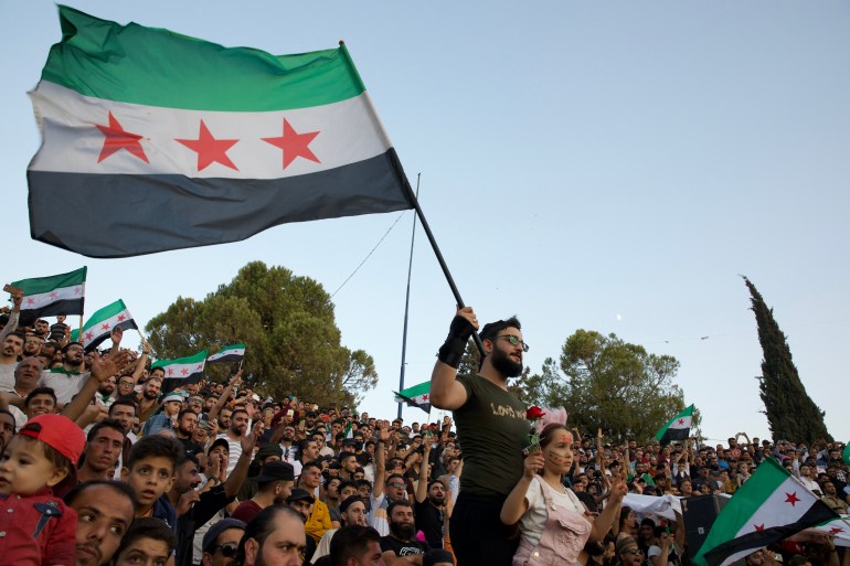 Protesters carried the Syrian opposition flag