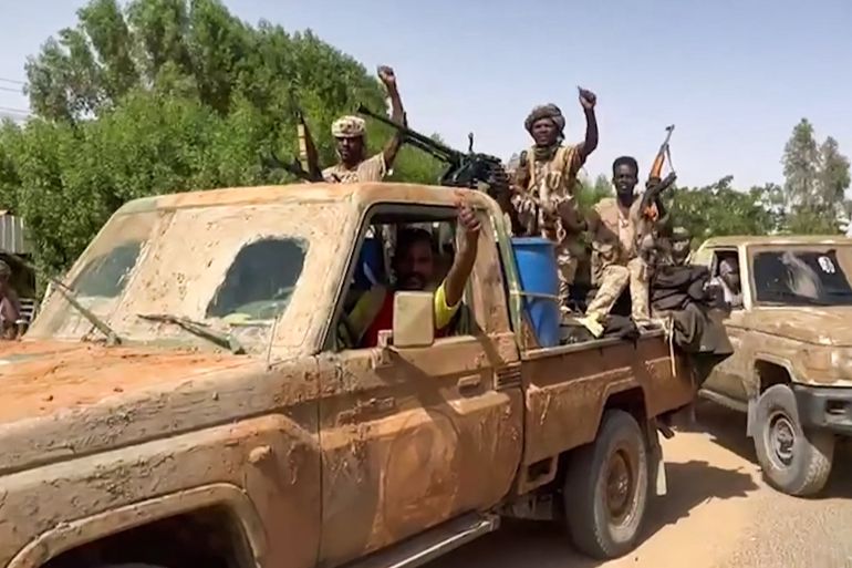 In this image grab taken from handout video footage released by the Sudanese paramilitary Rapid Support Forces (RSF) on April 23, 2023, fighters ride in the back of a technical vehicle (pickup truck mounted with a turret) in the East Nile district of greater Khartoum. - A US-brokered ceasefire between Sudan's warring generals entered its second day on April 26, 2023,