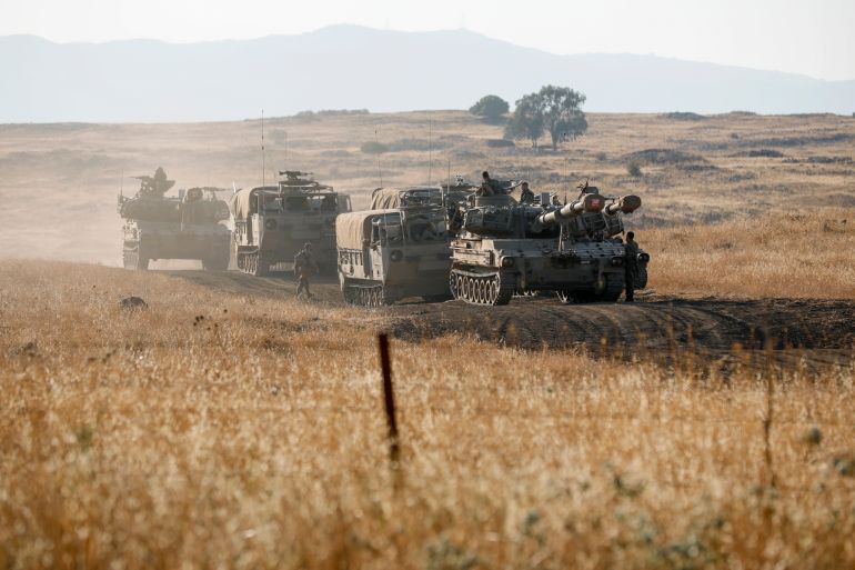 Soldados israelenses reposicionam veículos militares, incluindo artilharia autopropulsada, durante um exercício nas Colinas de Golã anexadas em 17 de julho de 2023.