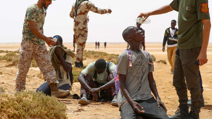 Libyan border guard provide water to migrants of African origin