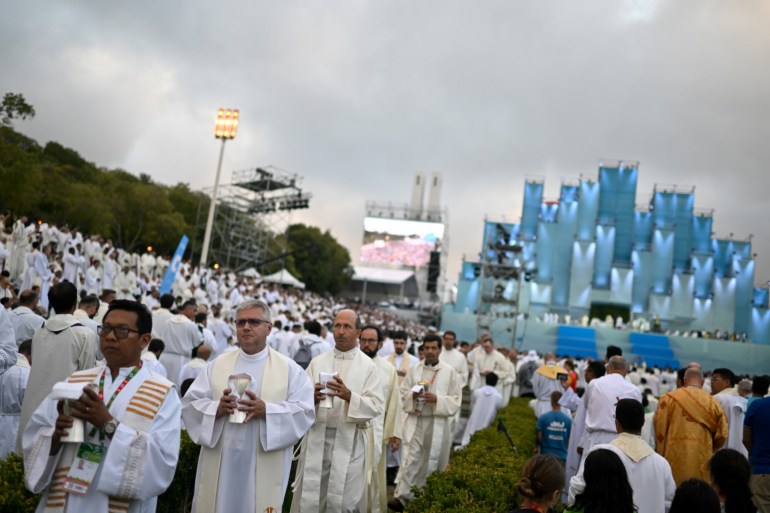 Members of the clergy attend the opening mass of the World Youth Day (WYD) gathering of young Catholics in Eduardo VII Park in Lisbon