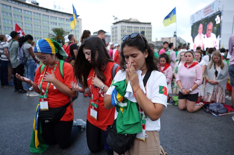 Pilgrims play during the opening mass of the World Youth Day (WYD) gathering of young Catholics in Eduardo VII Park in Lisbon