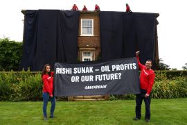 A handout picture taken and released by environmental action group Greenpeace on August 3, 2023 shows Greenpeace activists on the roof of Britain's Prime Minister Rishi Sunak's manor house in Kirby Sigston, northern England, to protest at his backing for new oil and gas licences in the North Sea