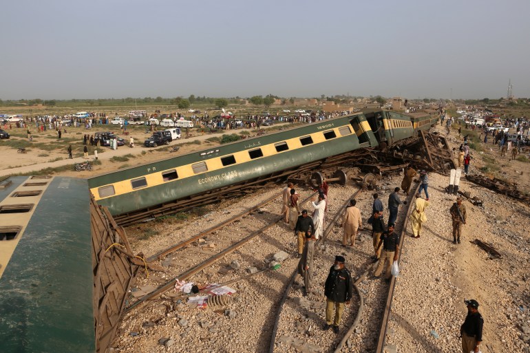 Police officials inspect the carriages at the accident site following the derailment of a passenger train in Nawabshah on August 6, 2023