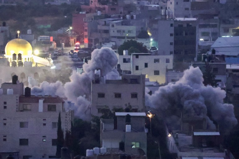 Smoke billows as Israeli soldiers demolish a house at the Askar camp