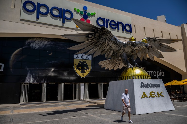 A man walks outside AEK Athens' OPAP Arena 