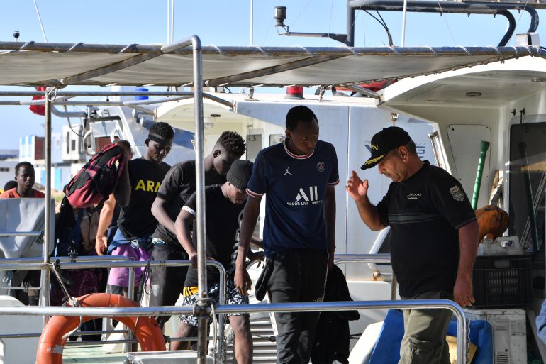 Migrants of African origin are escorted by Tunisian coast guards upon their arrival in Sfax aboard a military boat on August 9, 2023.
