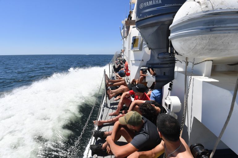 Tunisians trying to flee to Europe gather aboard a ship owned by the Tunisian coast guards, after being intercepted by them at sea