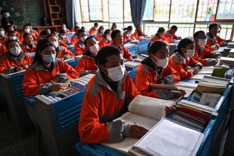 Students sitting in rows in matching red uniforms at a senior high school in Lhasa