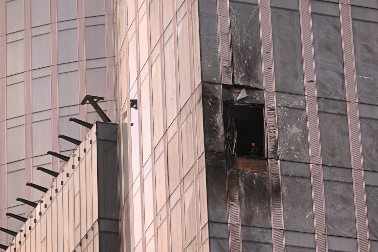 A woman inspects the damage sustained by a building of the Moscow International Business Center (Moskva City) following a drone attack in Moscow on August 23, 2023. - A Ukrainian drone attack on Moscow damaged a building in a central business district, authorities said on August 23, in the sixth straight night of aerial attacks on Russia's capital region. (Photo by NATALIA KOLESNIKOVA / AFP)