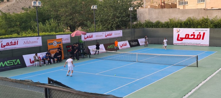 Footballer Mehdi Hobeh Darvish, left, with Amir Hossein Badi, one of Iran’s top tennis players, on an open-air tennis hardcourt located at the Espinas Palace Hotel [Courtesty of Mahmoud Najafzadeh]