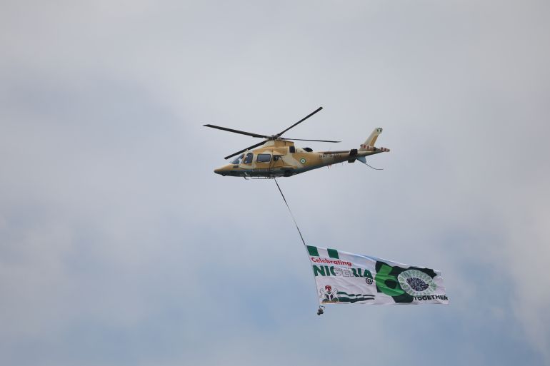 A Nigerian Air force helicopter fly a Nigerian 60th anniversary banner at the Aso-Rock in Abuja