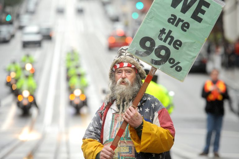 An Occupy protester, who declined to give his name, pickets outside a Bank of America branch on Friday, Jan. 20, 2012, in San Francisco. Anti-Wall Street demonstrators across the U.S. planned rallies Friday in front of banks and courthouses. (AP Photo/Noah Berger)