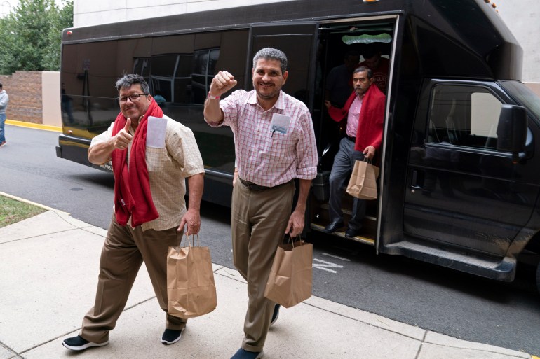 Two men step off a bus in Virginia. One raises a fist in celebration. The other flashes a thumbs-up.