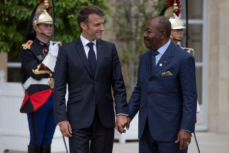 French President Emmanuel Macron, left, holds the hand of President of Gabon Ali Bongo at the Elysee Palace, Thursday, June 22, 2023 in Paris.