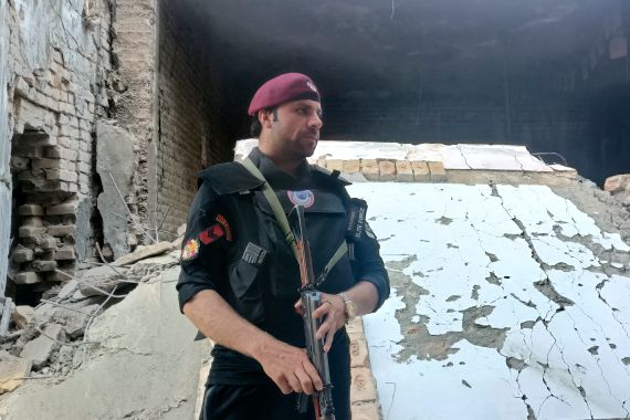 A security member stands guard inside a damages police compound after a suicide bomber attack in the Bara Khyber Pakhtunkhwa, Pakistan, Thursday, July 20, 2023