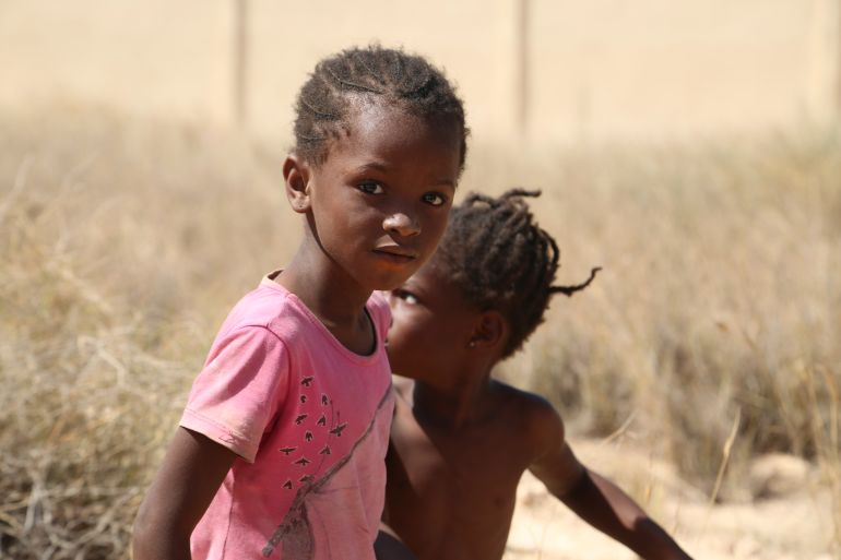 Two children look at the camera as they are stranded in the desert