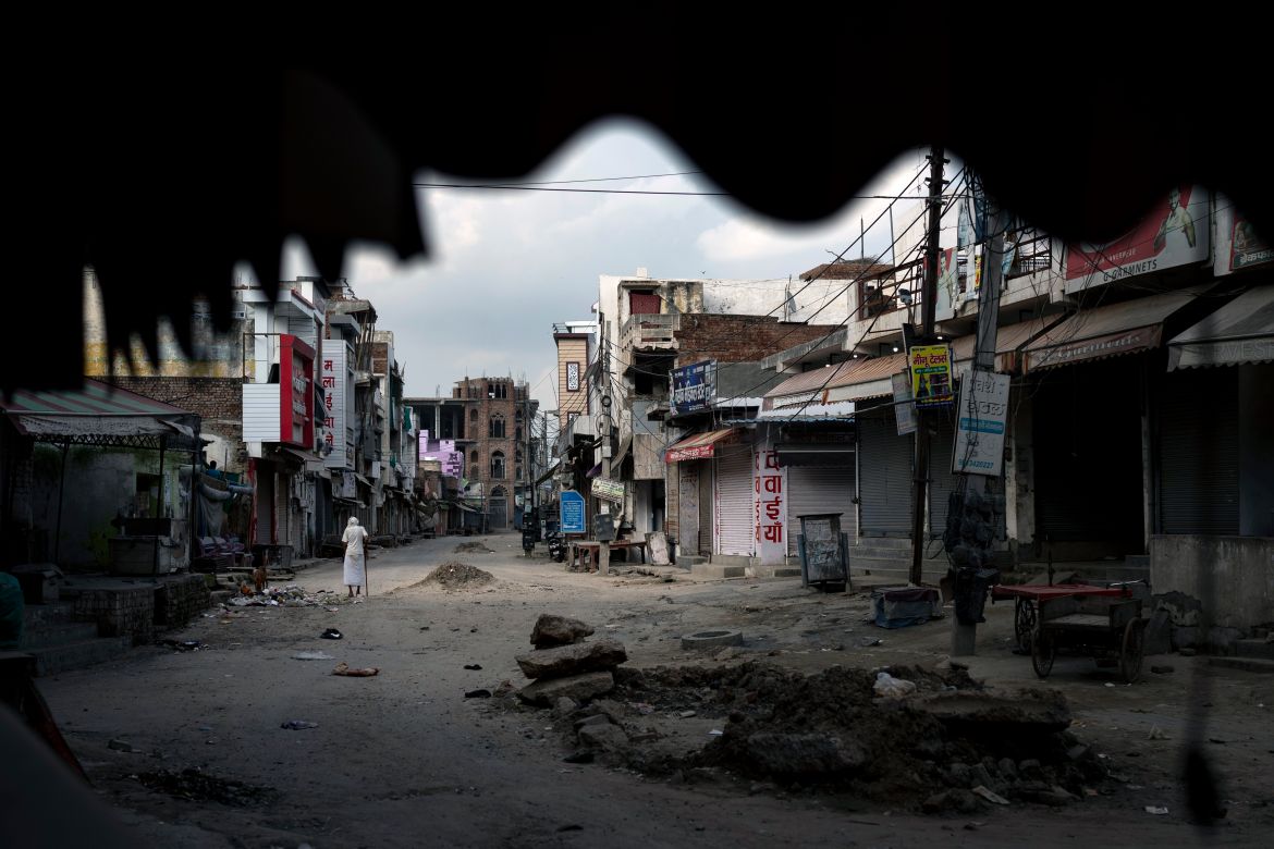 An elderly man walks in an area deserted after communal clashes in Nuh in Haryana state, India, Tuesday