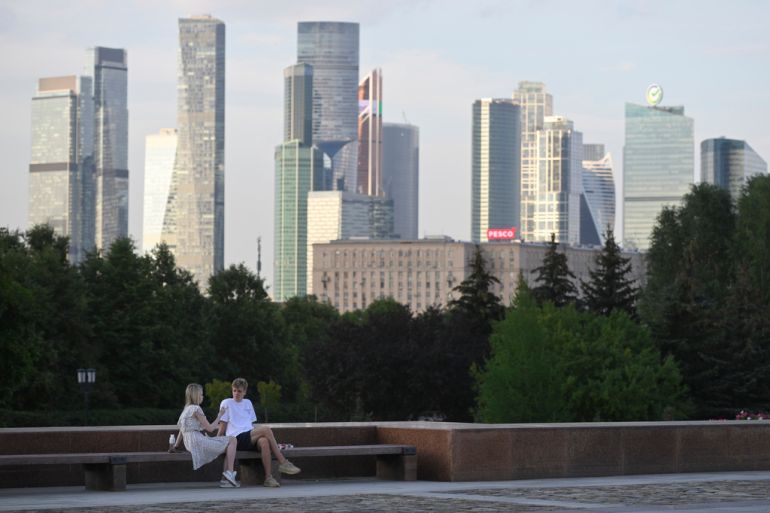 A couple sit in a park in Moscow, Russia, Tuesday, Aug. 1, 2023, with the "Moscow City" business district in the background. The glittering towers of the Moscow City business district were once symbols of the Russian capital's economic boom in the early 2000s. Now they are a sign of its vulnerability, following a series of drone attacks that rattled some Muscovites shaken and brought the war in Ukraine home to the seat of Russian power. (AP Photo/Dmitry Serebryakov)