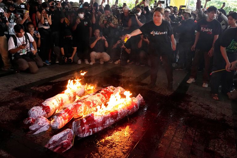 Supporters of the Move Forward Party burn an effigy during a protest at Pheu Thai Party headquarters in Bangkok, Thailand, Wednesday, August 2, 2023.