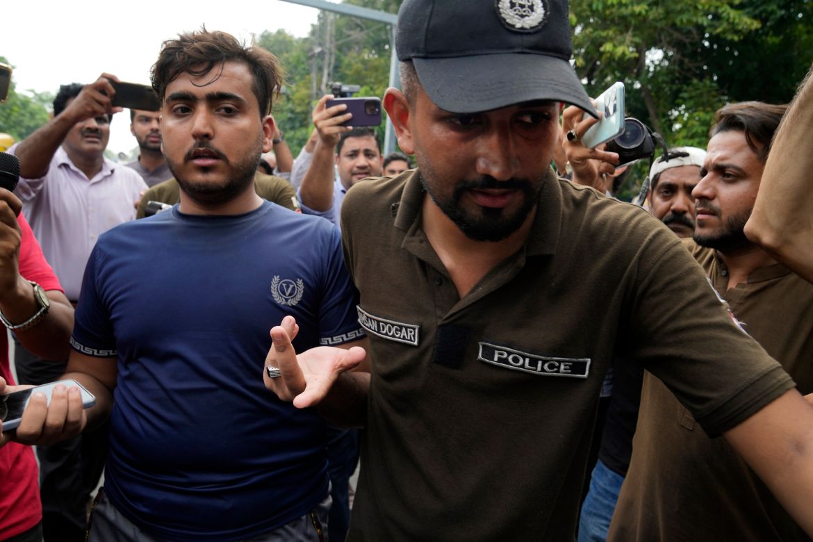 Police officer detain a supporter of Pakistan's former Prime Minister Imran Khan
