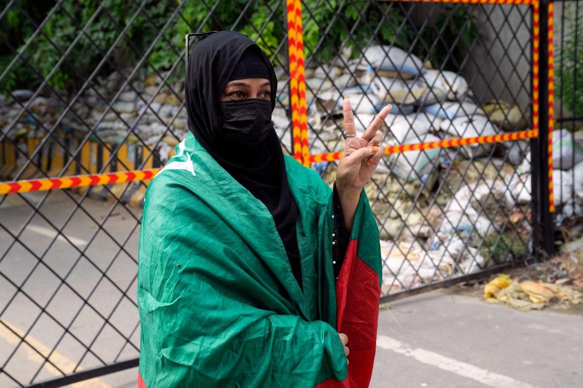 A supporter of Pakistan's former Prime Minister Imran Khan, covers herself with his PTI party flag