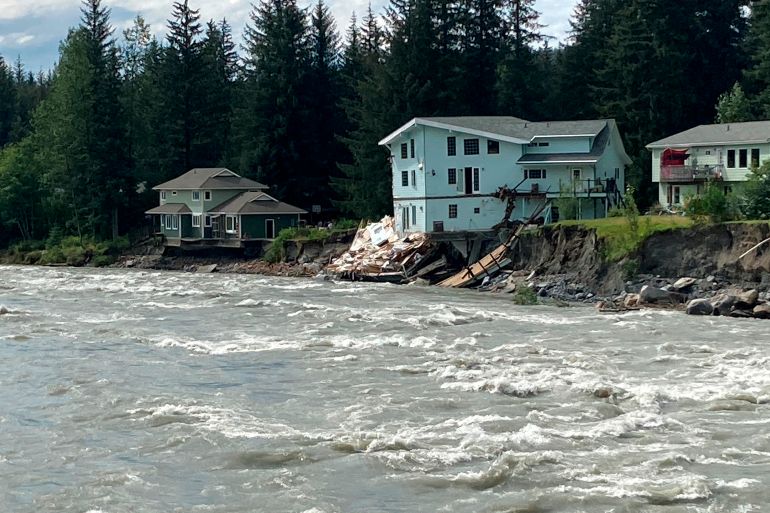 The swollen Mendenhall River courses along a neighborhood in Juneau, Alaska