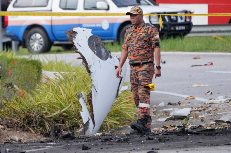 A member of the fire and rescue department inspect the crash site of a small plane in Shah Alam district, Malaysia