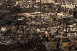 A person with a face covering visits a residential area devastated by a recent wildfire in Lahaina, Hawaii, Monday, Aug. 21, 2023. (AP Photo/Jae C. Hong)