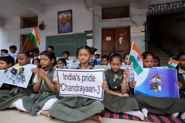 Students holds posters and pray for the successful landing of India's moon craft Chandrayaan-3, on the moon surface, at a school in Ahmedabad