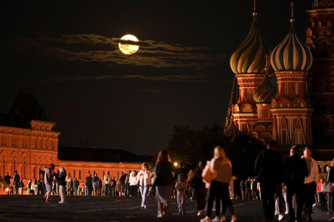 he August Super Blue Moon sets behind a historical building and the St. Basil's Cathedral