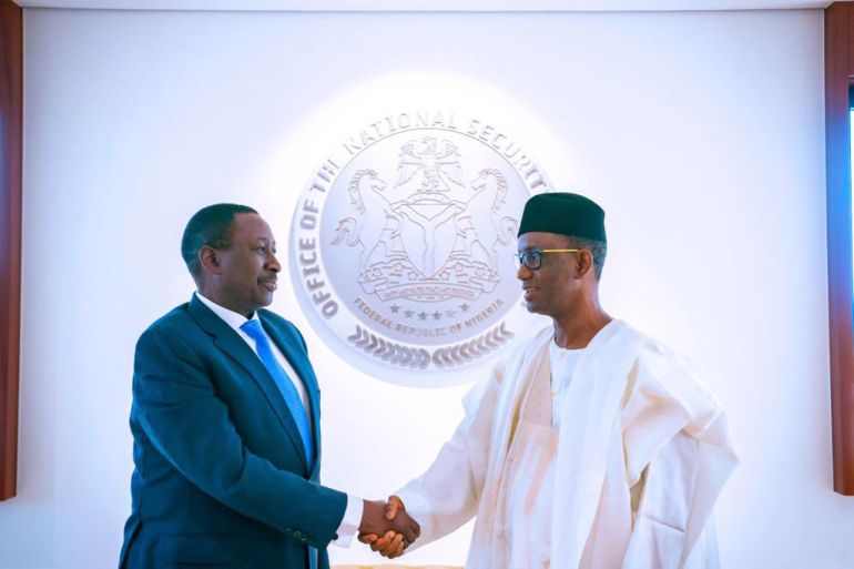 Nigeria's new National Security Adviser Nuhu Ribadu (r) in a handshake with his immediate predecessor Babagana Monguno