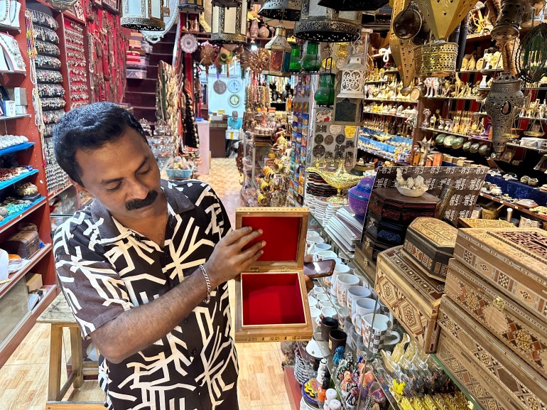 Razzaq shows an engraved wooden box for sale in the one of the shops he works in 