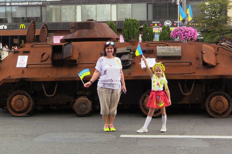 People stand in front of tank