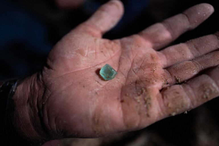 Abdul Qadr shows off a small tourmaline he pulled out of the rubble.