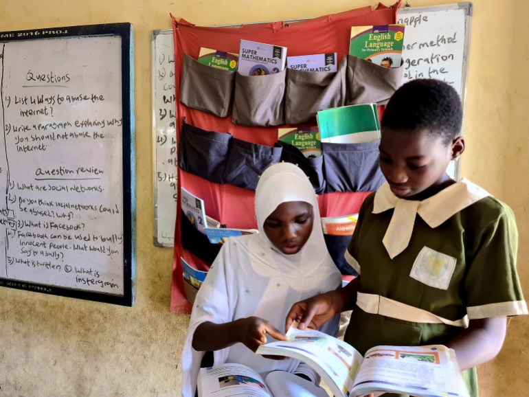 Two students read in front of the hanging library at a school in Lagos