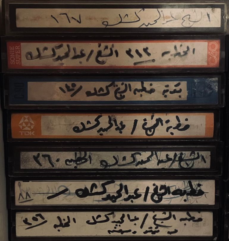a stack of seven cassettes with recordings of Sheikh Kishk, handwritten labels as they are blanks