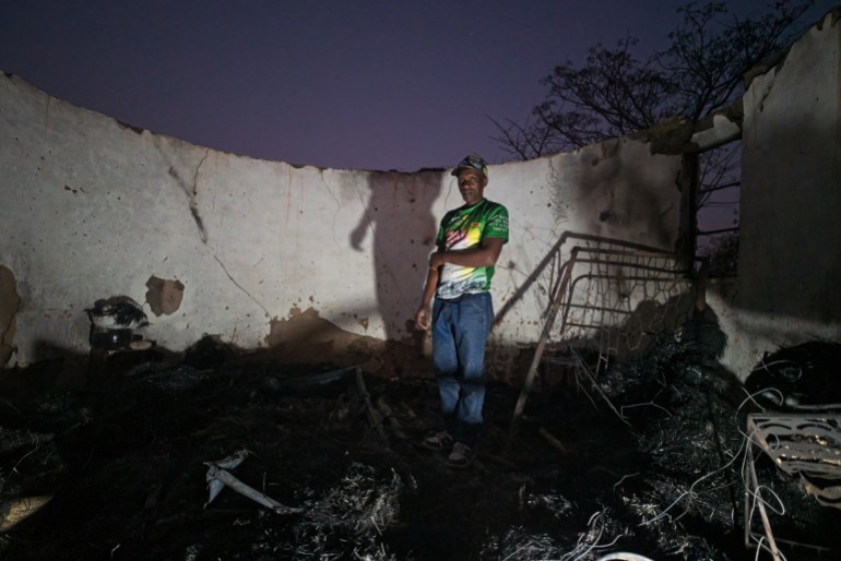 Shepherd Mahove, 48, stands in a burnt bedroom at his former homestead in Hanke B Village, Zimbabwe