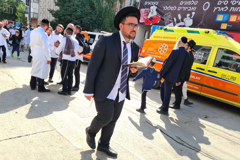 Um peregrino com um livro de orações caminhando pela rua Pushkin, no centro de Uman