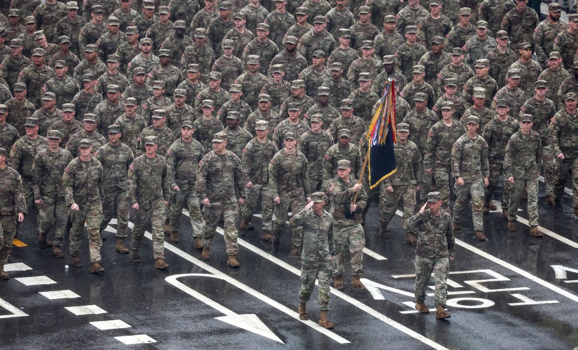 A contingent of US troops from the 2nd Infantry Division's Stryker Brigade. They are marching behind their unit flag