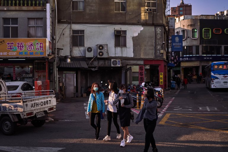 A photo of pedestrians walking along a street in Kinmen.