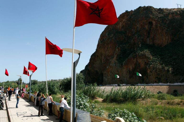 People stand near a border post on the Algerian side of the Morocco-Algeria border in the north east of Morocco