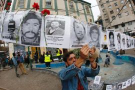 An activist hangs images of people who were forcibly disappeared during Chile's military dictatorship